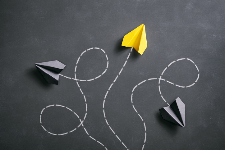 Conceptual photography with black and yellow paper airplanes on a smudged blackboard.