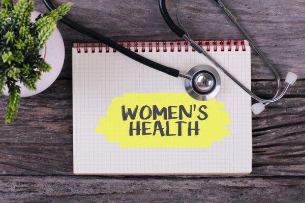 Women's Health word on notebook,stethoscope and green plant