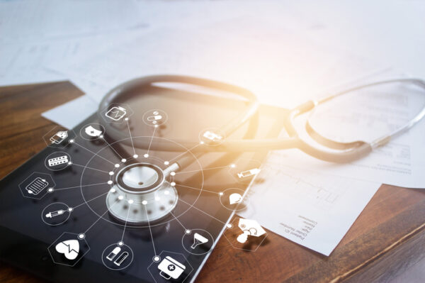 Stethoscope with icon medical on tablet and wooden table background