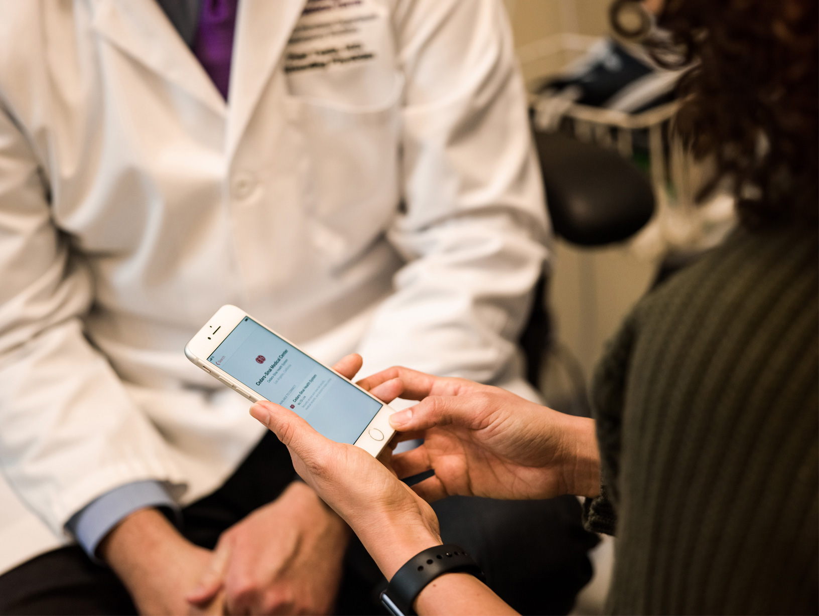 Image of patient showing doctor her health records on phone