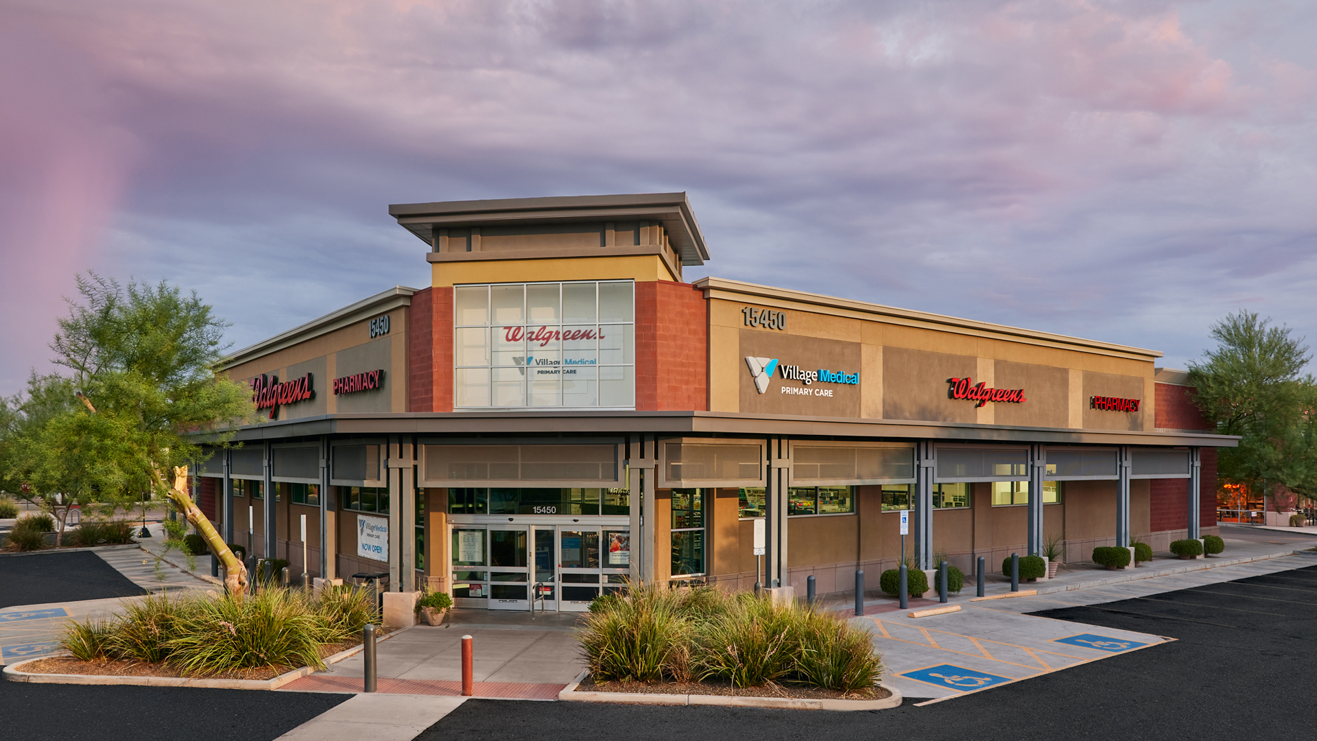 A Walgreens store in Phoenix shows a sign for Village Medical primary care on the side, along with a now open sign. 