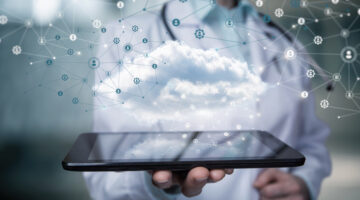 Doctor shows healthcare data cloud on tablet on blurred background.