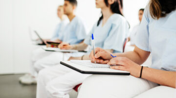 A group of nurses taking notes during a lecture at university.