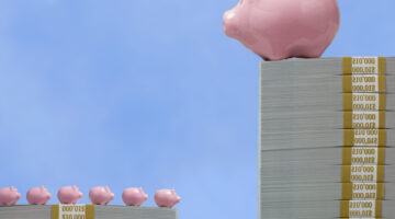 One very large ceramic piggy bank on tall pile of US paper currency looking down on 6 much small piggy banks