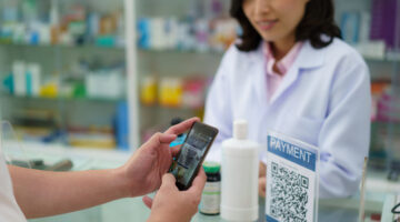 Asian man customer to scan the payment QR code to buy drug in pharmacy.