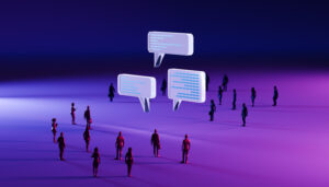 Three translucent speech bubbles float centrally above a group of monochrome business professionals. The figures in the foreground are subtly tinted with purple hues, while those in the background shift to soft blue tones, all unified under atmospheric blue and purple lighting. This conceptual image highlights themes of communication, digital collaboration, and the intersection of human interaction with technology in a modern corporate environment. Perfect for illustrating teamwork, AI-driven dialogue, and futuristic business networking.