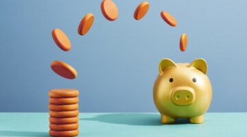 Coins moving from a stack to a piggy bank