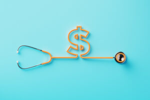 Orange stethoscope forming a dollar sign on blue background. Horizontal composition with clipping path and copy space. Directly above.