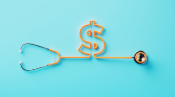 Orange stethoscope forming a dollar sign on blue background. Horizontal composition with clipping path and copy space. Directly above.