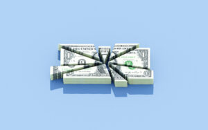 Bundle of dollars getting cut into various sizes, funding cut, Medicaid cuts