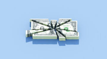 Bundle of dollars getting cut into various sizes, funding cut, Medicaid cuts