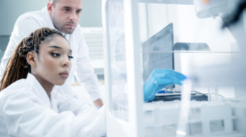 Multiracial scientists conducting medical tests and collecting results in a pharmaceutical laboratory.