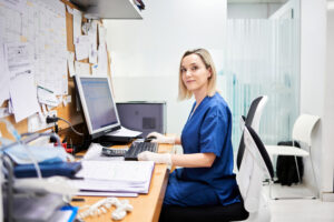 Female worker turning to face the camera while sitting in the office of a clinical analysis laboratory