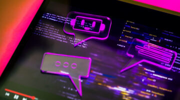 Ai chatbot interface on a screen with glowing pink speech bubbles representing conversation and coding language for artificial intelligence development