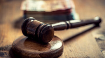 Corruption in the judiciary, the judge's gavel and euro banknotes in an envelope. Representation of corruption and bribery in the judiciary.