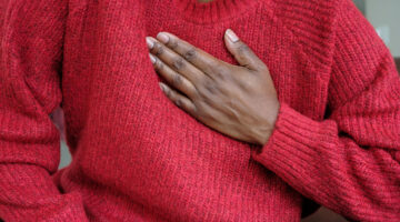 Close-up of unrecognizable black woman holding her chest in pain