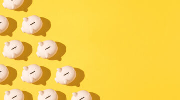 Little pink ceramic piggy bank pattern on the left side on yellow background. Concept of saving money, savings.