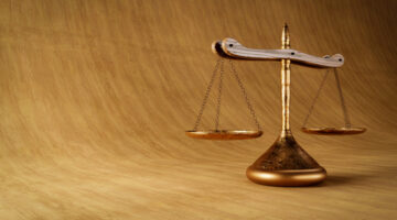 3D illustration of old scales over wooden textured background. Scales of justice symbol concept.