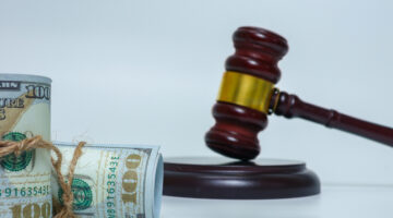 Judge gavel and bundled cash on white background representing financial crime, corruption, and legal consequences