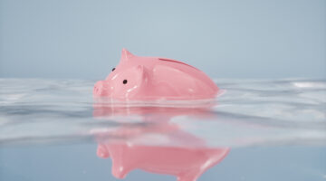 Sinking piggy bank in the water.