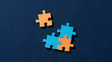 Paper Craft of the Final Piece to Solving a Jigsaw Puzzle on Blue Background Directly Above View.