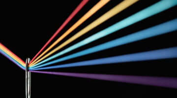 Rainbow Refraction by Color Threads Through Needle Eyelet on Black Background Macrophotography, Selective Focus.